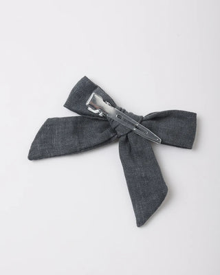 Close-up of a midnight blue linen bow hair clip with a metal alligator clip, shown against a white background.