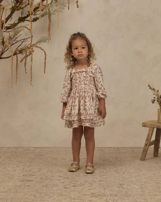 Toddler girl standing in ivory floral toile dress with square neckline and lace trim skirt