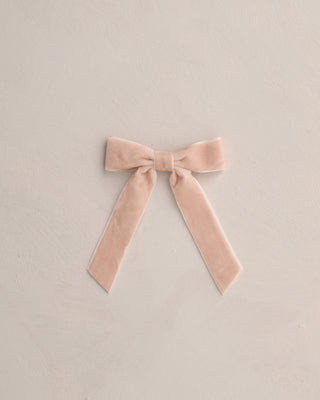 Pink velvet bow on a beige background