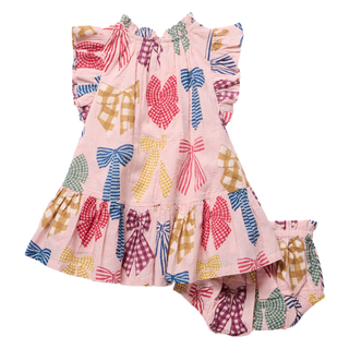 Product flat lay, back view, of a pink dress and matching bloomer shorts covered in a colorful printed bow pattern, featuring ruffle sleeves, a tiered ruffle skirt, and a red satin bow accent on the bloomers, on a white background.