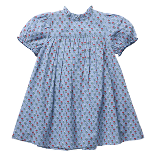 Product flat lay, back view, of a light blue dress with a red and white carnation blockprint, featuring puff sleeves with ruffled cuffs, a ruffled neckline, and a gathered pleated skirt, on a white background.