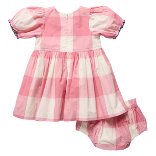 Product flat lay, back view, of a pink and cream check dress and matching bloomer shorts, featuring puff sleeves, navy trim on the cuffs, and a back zipper closure, on a white background.