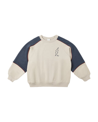 Beige and navy sweatshirt with a small graphic on a white background