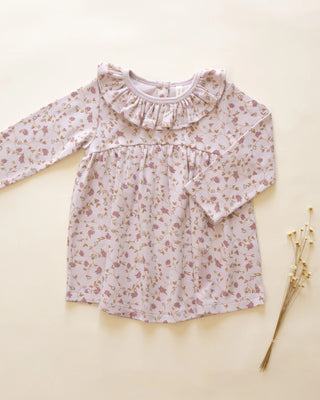 Floral blouse with ruffled collar on a beige background