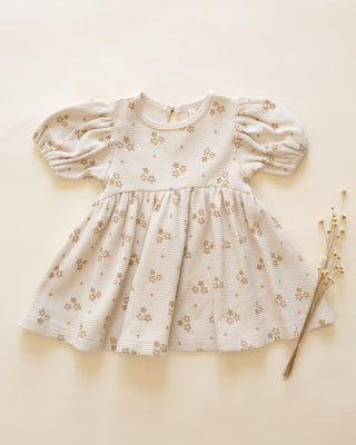 Baby dress with floral pattern on a beige background