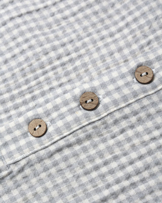 Close-up of a gray and white checkered fabric with wooden buttons.