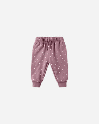 Pink baby pants with white polka dots on a light gray background