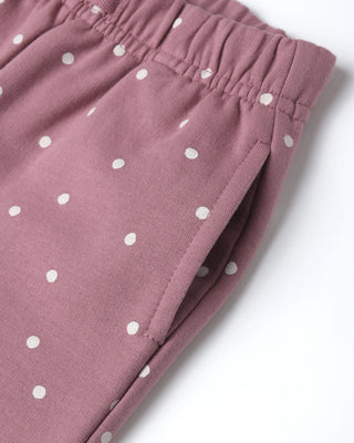 Pink pants with white polka dots on a light gray background