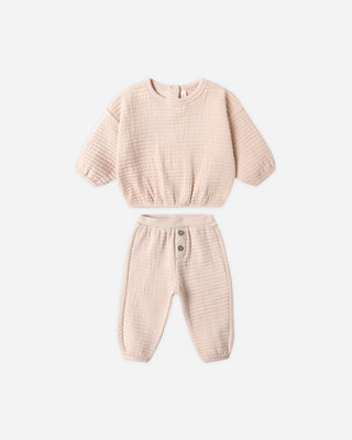 Beige children's outfit with top and pants on a white background