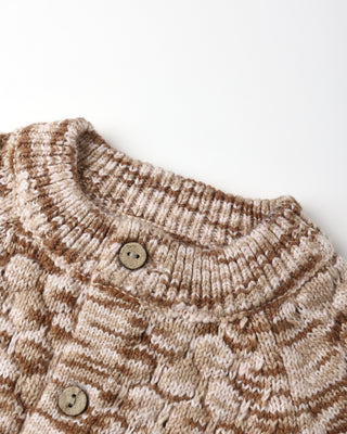Close-up of a knitted garment with a button on a light background