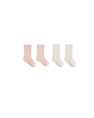 Set of four pairs of socks in pink and white on a white background