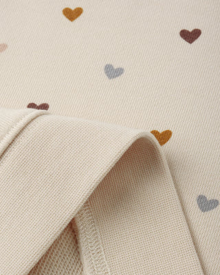 Close-up of a textured fabric with heart patterns on a beige background