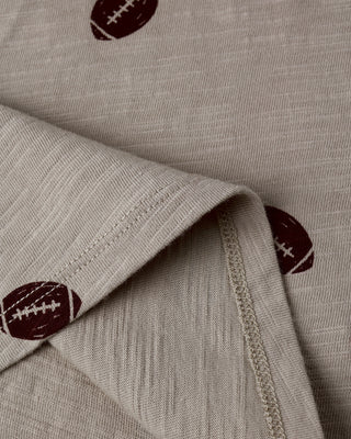 Close-up of beige fabric with brown football patterns