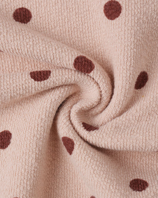 Close-up of beige fabric with brown polka dots