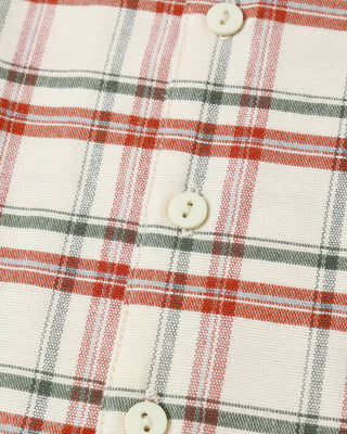 Close-up of a plaid shirt with red, green, and white pattern.