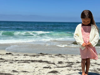 Young girl standing on a beach with ocean waves in the background