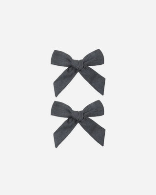 Two midnight blue linen bow hair clips arranged vertically on a white background.
